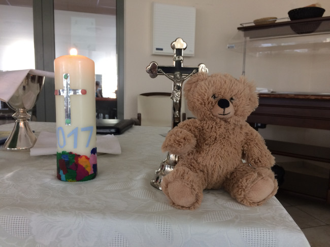 Ein Altar mit Kreuz, brennender Kerze und Teddybär